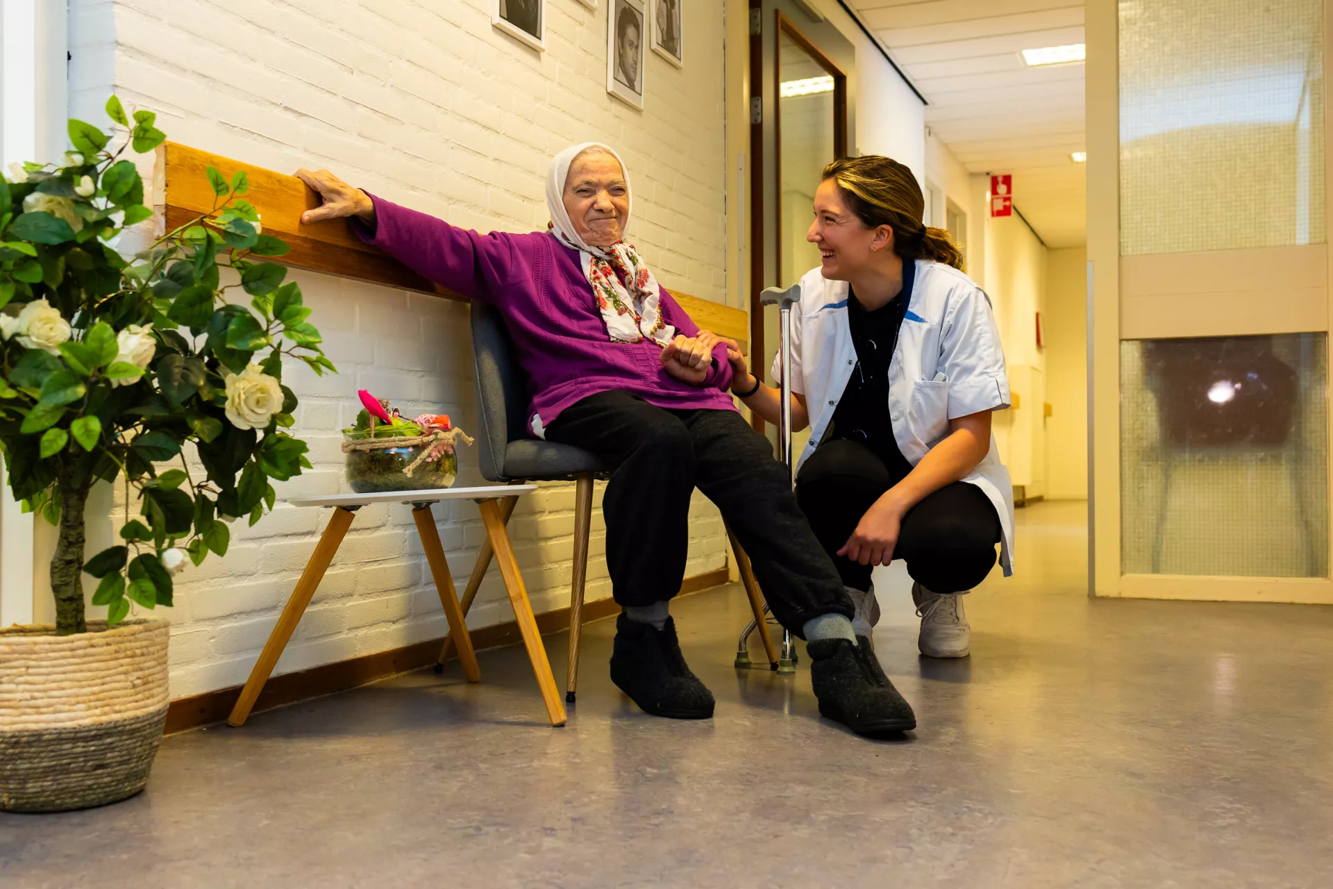 Bewoner op een bankje in de hal